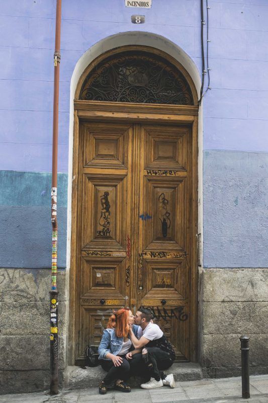 Retrato fotográfico. Una pareja se besa en la puerta de un edificio