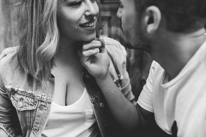 retrato. Un hombre roza la barbilla de una mujer que sonríe