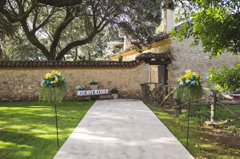 Una alfombra muestra el camino a la ceremonia, hay un cartel de bienvenida