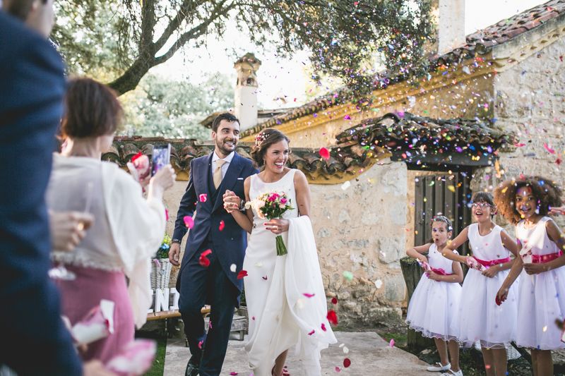 Los invitados tiran arroz y pétalos a los novios en su salida de la ceremonia