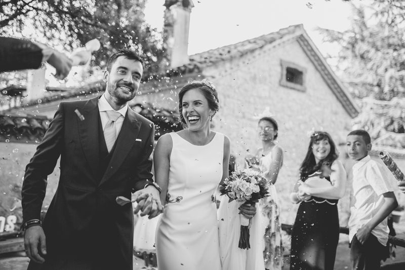 Retrato de los novios la salida de la ceremonia cuando les tiran arroz